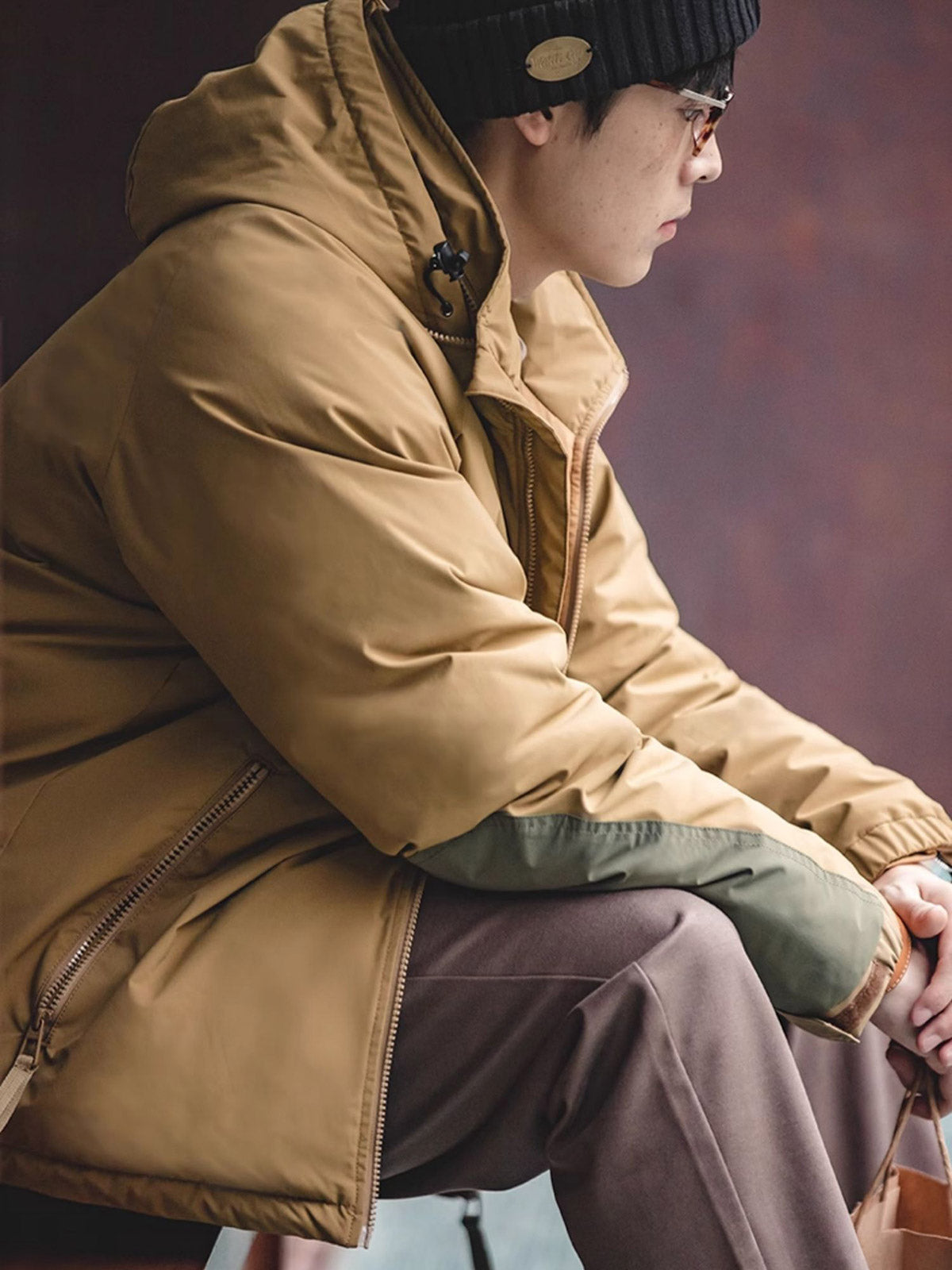 詳細画像
マットな光沢のナイロン生地、取り外し可能な防風フード、裾のエラスティックドローコードが実用性を高め、寒風を防ぎます。多層構造でダウンの膨らみを保ちつつ、優れた保温性を発揮します。シンプルでスリムなラインが特徴。
モデル画像
ECWCS L7スタイルのフード付きダウンジャケットを着用したモデル、冬の寒さにも対応できる優れた保温性とスタイリッシュなデザインが際立つ。