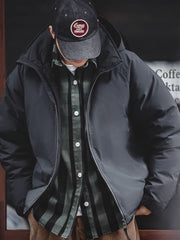 詳細画像
マットな光沢のナイロン生地、取り外し可能な防風フード、裾のエラスティックドローコードが実用性を高め、寒風を防ぎます。多層構造でダウンの膨らみを保ちつつ、優れた保温性を発揮します。シンプルでスリムなラインが特徴。
モデル画像
ECWCS L7スタイルのフード付きダウンジャケットを着用したモデル、冬の寒さにも対応できる優れた保温性とスタイリッシュなデザインが際立つ。