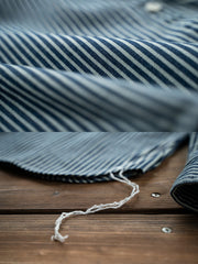 製品画像: レトロなアメリカン鉄道ストライプデザインが特徴の長袖シャツ。クラシックなアメカジスタイルを演出する精緻なストライプ模様と、耐久性と機能性を兼ね備えた実用的なアイテム。
詳細画像: 1930年代の鉄道文化からインスパイアされたストライプデザインのディテール。ダブル胸ポケットとクラシックな開襟が特徴的で、100%コットン素材の快適な着心地。