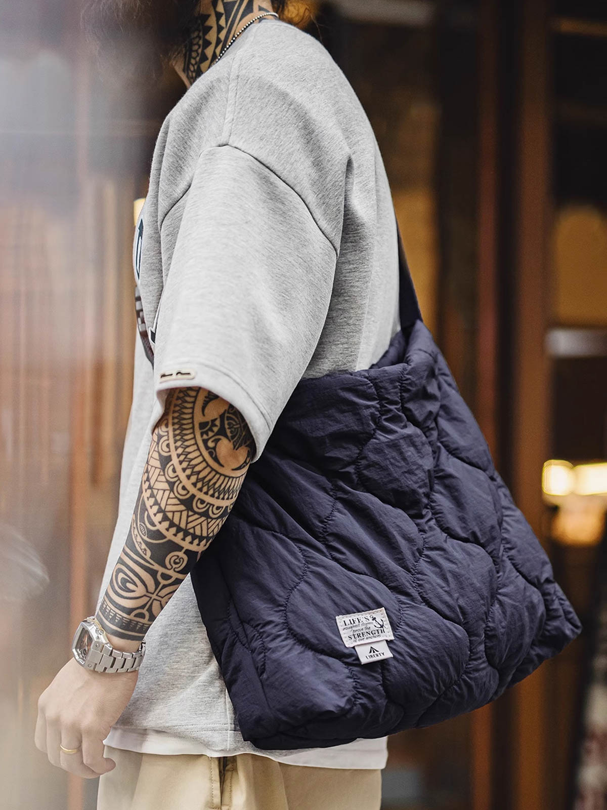 詳細画像: 貝殻模様キルティングデザインのアップ、310Tマット仕上げしわ感ナイロンと立体充填素材のディテール。
モデル画像: モデルが大容量の貝殻模様雲形バッグを肩掛けして、日常使いに最適なスタイルを披露。