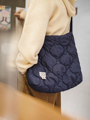 詳細画像: 貝殻模様キルティングデザインのアップ、310Tマット仕上げしわ感ナイロンと立体充填素材のディテール。
モデル画像: モデルが大容量の貝殻模様雲形バッグを肩掛けして、日常使いに最適なスタイルを披露。