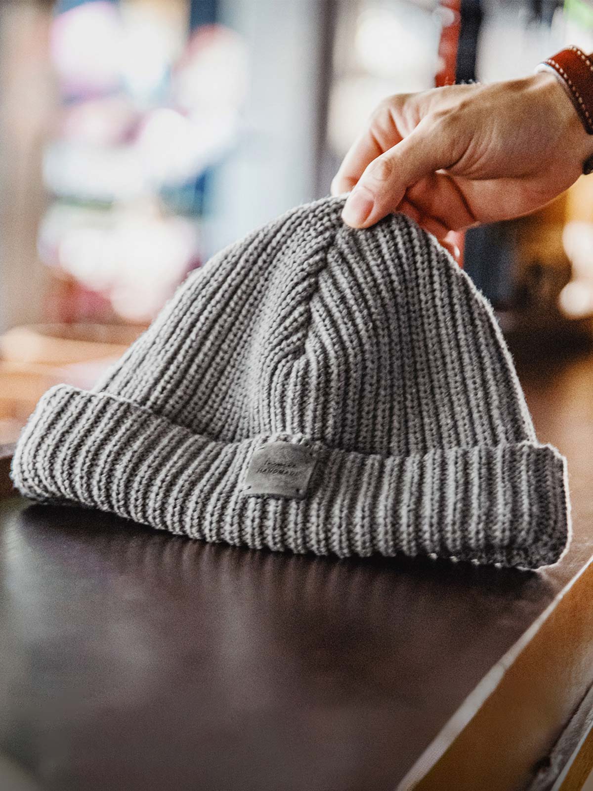 製品画像: ヴィンテージ風ローゲージニットキャップ 冬 メンズ 保温 アメリカンスタイル 全体画像
詳細画像: ハンドメイドのレザーパッチとクラシックなローゲージ編みディテール