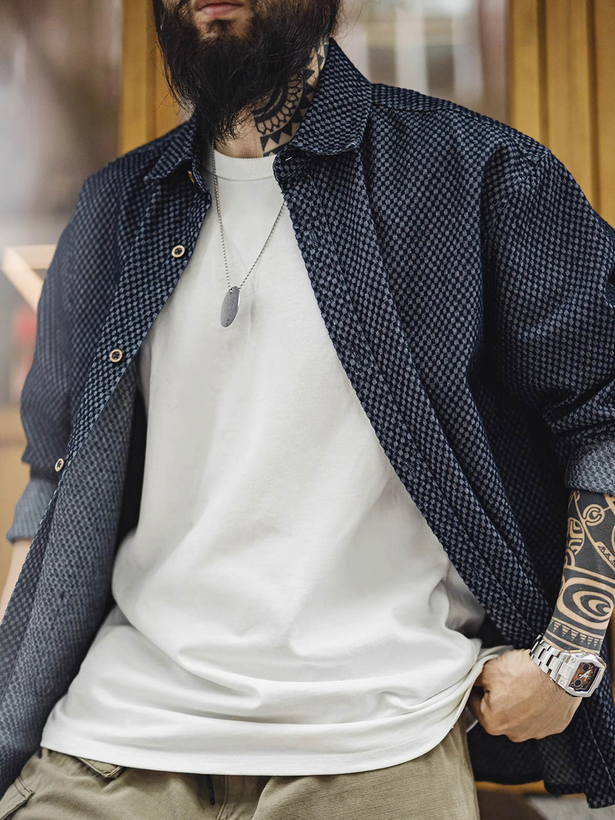 詳細画像
チェッカーボード柄のディテールと、しっかりとしたデニム生地の質感を強調した画像。耐久性のある縫製と、ボタンのディテールが特徴的。
モデル画像
チェッカーボードデニムシャツを着用したモデル。レトロストリートスタイルを体現し、カジュアルな日常シーンでのスタイリングを提案。