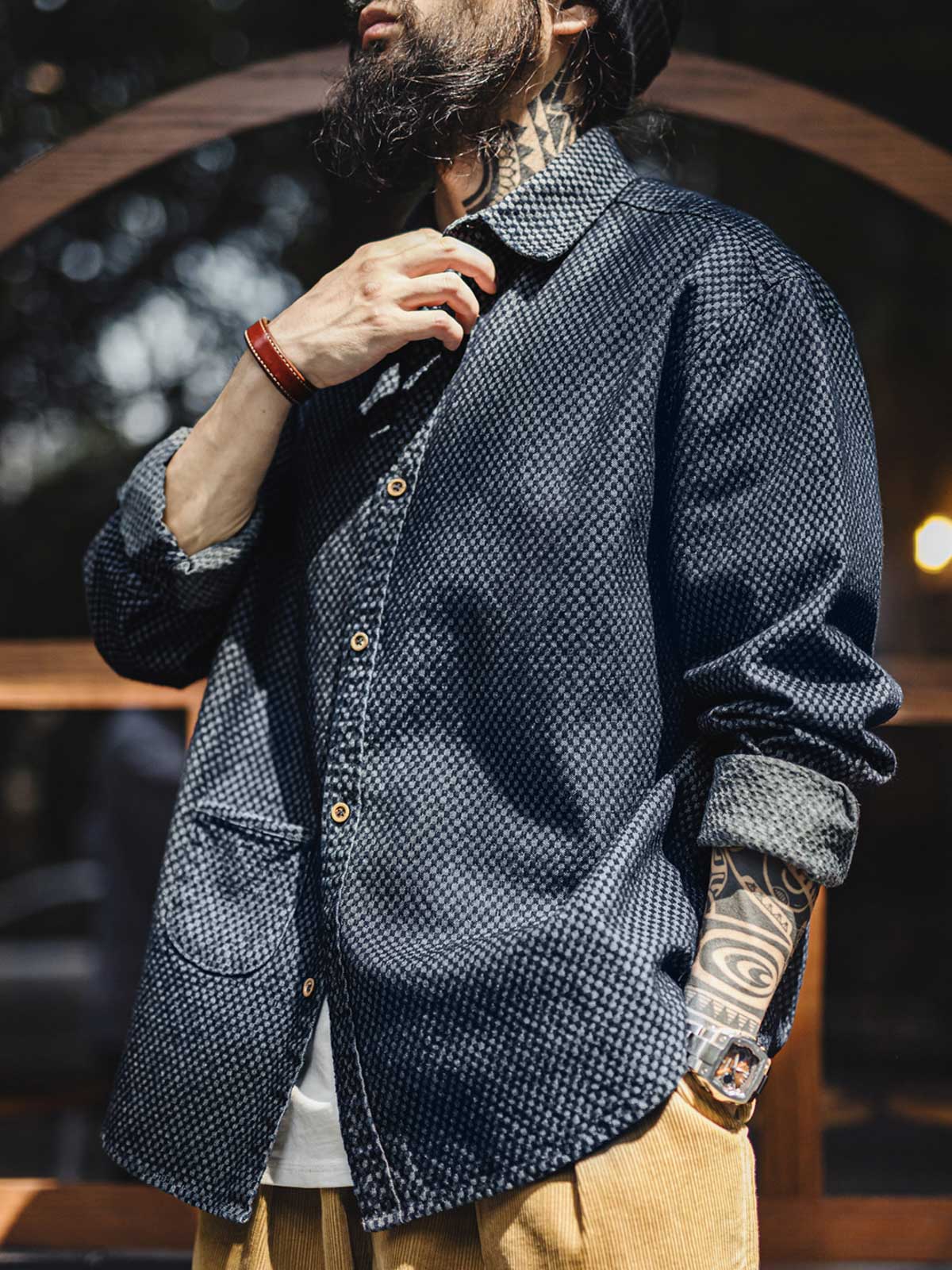 詳細画像
チェッカーボード柄のディテールと、しっかりとしたデニム生地の質感を強調した画像。耐久性のある縫製と、ボタンのディテールが特徴的。
モデル画像
チェッカーボードデニムシャツを着用したモデル。レトロストリートスタイルを体現し、カジュアルな日常シーンでのスタイリングを提案。