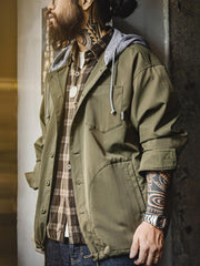 詳細画像
「耐久性に優れたヘリンボーン生地とヴィンテージ感を引き立てるレーザーボタン、明るいステッチラインのディテールをクローズアップした画像。」
モデル画像
「モデルがレイヤード風 パッチワーク フード付きワークジャケットを着用し、レトロなワークウェアと現代のアーバンスタイルを融合したコーディネートを披露。」