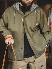 詳細画像
「耐久性に優れたヘリンボーン生地とヴィンテージ感を引き立てるレーザーボタン、明るいステッチラインのディテールをクローズアップした画像。」
モデル画像
「モデルがレイヤード風 パッチワーク フード付きワークジャケットを着用し、レトロなワークウェアと現代のアーバンスタイルを融合したコーディネートを披露。」