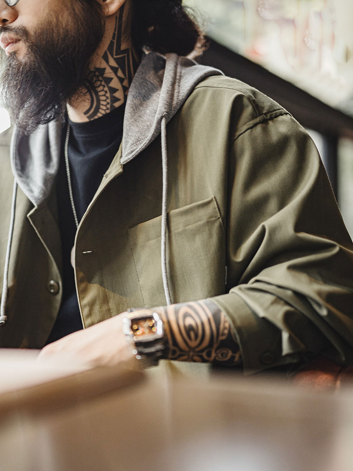 詳細画像
「耐久性に優れたヘリンボーン生地とヴィンテージ感を引き立てるレーザーボタン、明るいステッチラインのディテールをクローズアップした画像。」
モデル画像
「モデルがレイヤード風 パッチワーク フード付きワークジャケットを着用し、レトロなワークウェアと現代のアーバンスタイルを融合したコーディネートを披露。」