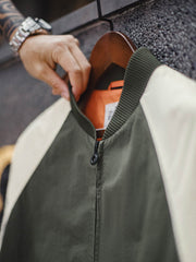 バイカラーのラグランスリーブとオレンジ色の裏地、ブラック六角形ジッパーの特写