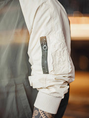 バイカラーのラグランスリーブとオレンジ色の裏地、ブラック六角形ジッパーの特写