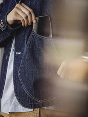 詳細画像
大容量のダブルインサートポケットや丸みを帯びた裾デザイン、ツイル織りテクスチャーのディテールを強調したショット。自然なウォッシュ加工の風合いも表現。
モデル画像
ライトカラーのTシャツとワークパンツを合わせたストリートスタイルを披露するモデルが着用したウォッシュデニムジャケット。現代的なワーク感が際立つコーディネート。