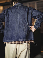 詳細画像
大容量のダブルインサートポケットや丸みを帯びた裾デザイン、ツイル織りテクスチャーのディテールを強調したショット。自然なウォッシュ加工の風合いも表現。
モデル画像
ライトカラーのTシャツとワークパンツを合わせたストリートスタイルを披露するモデルが着用したウォッシュデニムジャケット。現代的なワーク感が際立つコーディネート。