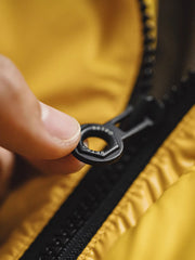 製品画像
鮮やかなイエローのハイカラー・ダウンジャケット、80年代のパニナーロスタイルを再現、撥水性4級のナイロン防水素材、クラシックなデザインと高襟が特徴のジャケット
詳細画像
六角形ジッパーチャームとインディアン柄刺繍ディテール、鮮やかなイエローが際立つデザイン、防水加工されたナイロン素材とレトロなディテールのクローズアップ