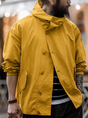 詳細画像
スタンドカラーと折り襟の2WAY仕様、エポレットディテール、フラップ付きスナップボタンポケット、そしてドローコード付き裾のディテールを強調したクローズアップ画像。機能性とデザイン性が融合した細部。
モデル画像
リラックス感のあるオーバーサイズシルエットのヴィンテージフード付きジャケットを着用し、アウトドアコーディネートを演出したモデル画像。軽量で耐久性のあるデザインが際立つスタイル。