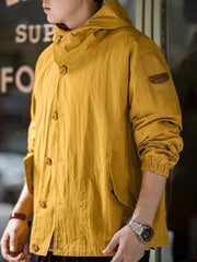 詳細画像
スタンドカラーと折り襟の2WAY仕様、エポレットディテール、フラップ付きスナップボタンポケット、そしてドローコード付き裾のディテールを強調したクローズアップ画像。機能性とデザイン性が融合した細部。
モデル画像
リラックス感のあるオーバーサイズシルエットのヴィンテージフード付きジャケットを着用し、アウトドアコーディネートを演出したモデル画像。軽量で耐久性のあるデザインが際立つスタイル。