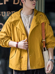 詳細画像
スタンドカラーと折り襟の2WAY仕様、エポレットディテール、フラップ付きスナップボタンポケット、そしてドローコード付き裾のディテールを強調したクローズアップ画像。機能性とデザイン性が融合した細部。
モデル画像
リラックス感のあるオーバーサイズシルエットのヴィンテージフード付きジャケットを着用し、アウトドアコーディネートを演出したモデル画像。軽量で耐久性のあるデザインが際立つスタイル。