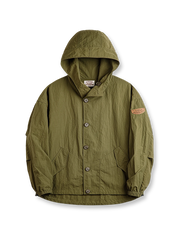 製品画像
タスロン素材のシワ加工が特徴的な薄手フード付きジャケット全体画像。エポレットデザインとヴィンテージ感漂うテクスチャーが、アウトドアや日常のあらゆるシーンで活躍する一着。
詳細画像
スタンドカラーと折り襟の2WAY仕様、エポレットディテール、フラップ付きスナップボタンポケット、そしてドローコード付き裾のディテールを強調したクローズアップ画像。機能性とデザイン性が融合した細部。