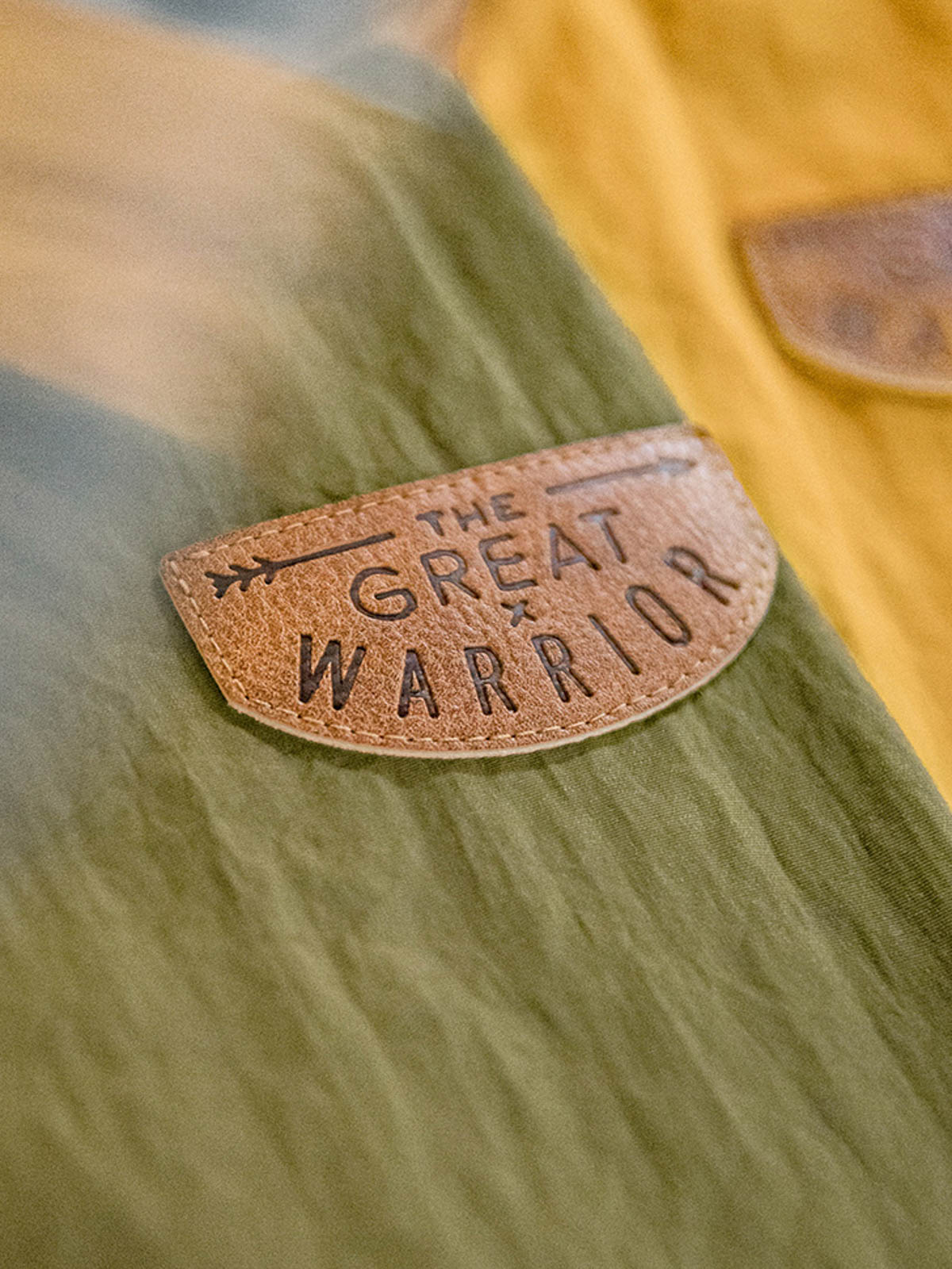 製品画像
タスロン素材のシワ加工が特徴的な薄手フード付きジャケット全体画像。エポレットデザインとヴィンテージ感漂うテクスチャーが、アウトドアや日常のあらゆるシーンで活躍する一着。
詳細画像
スタンドカラーと折り襟の2WAY仕様、エポレットディテール、フラップ付きスナップボタンポケット、そしてドローコード付き裾のディテールを強調したクローズアップ画像。機能性とデザイン性が融合した細部。