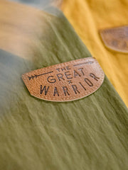 製品画像
タスロン素材のシワ加工が特徴的な薄手フード付きジャケット全体画像。エポレットデザインとヴィンテージ感漂うテクスチャーが、アウトドアや日常のあらゆるシーンで活躍する一着。
詳細画像
スタンドカラーと折り襟の2WAY仕様、エポレットディテール、フラップ付きスナップボタンポケット、そしてドローコード付き裾のディテールを強調したクローズアップ画像。機能性とデザイン性が融合した細部。