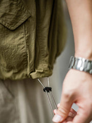 製品画像
タスロン素材のシワ加工が特徴的な薄手フード付きジャケット全体画像。エポレットデザインとヴィンテージ感漂うテクスチャーが、アウトドアや日常のあらゆるシーンで活躍する一着。
詳細画像
スタンドカラーと折り襟の2WAY仕様、エポレットディテール、フラップ付きスナップボタンポケット、そしてドローコード付き裾のディテールを強調したクローズアップ画像。機能性とデザイン性が融合した細部。