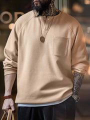 詳細画像
幾何学模様のワッフル編みテクスチャー、袖口のリブディテール、裾のドローストリングデザインを強調したクローズアップ画像。ラグランスリーブと切り替えデザインが動きと立体感を演出。
モデル画像
ヴィンテージ感漂うヘンリーネックシャツを着用したモデルが、ラグランスリーブによるリラックスシルエットを活かしたカジュアルスタイルを披露。快適な着心地と立体的な編み地が目を引くコーディネート。