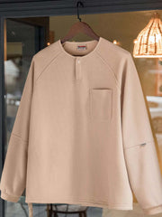 製品画像
立体感のあるワッフル編み素材を採用したヘンリーネックシャツの全体画像。ヴィンテージ感あふれるY字型ボタン付きデザインが特徴で、日常のカジュアルコーデやレイヤードスタイルにも最適。
詳細画像
幾何学模様のワッフル編みテクスチャー、袖口のリブディテール、裾のドローストリングデザインを強調したクローズアップ画像。ラグランスリーブと切り替えデザインが動きと立体感を演出。