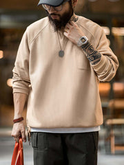 詳細画像
幾何学模様のワッフル編みテクスチャー、袖口のリブディテール、裾のドローストリングデザインを強調したクローズアップ画像。ラグランスリーブと切り替えデザインが動きと立体感を演出。
モデル画像
ヴィンテージ感漂うヘンリーネックシャツを着用したモデルが、ラグランスリーブによるリラックスシルエットを活かしたカジュアルスタイルを披露。快適な着心地と立体的な編み地が目を引くコーディネート。