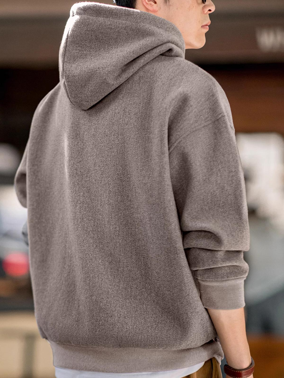 詳細画像
表面の細かい起毛デザインと、エンボスレザーラベル、袖口のリブ編みディテールが特徴。フードのドローコードと広めのポケットで、実用性とレトロなレイヤード感が強調されています。ダブルファブリックのミックス刺し毛加工が肌触りと保温性を向上。
モデル画像
冬のコーディネートに最適なウール混フード付きパーカーを着用したモデル。起毛デザインとレトロなディテールが際立ち、快適さと保温性を提供。