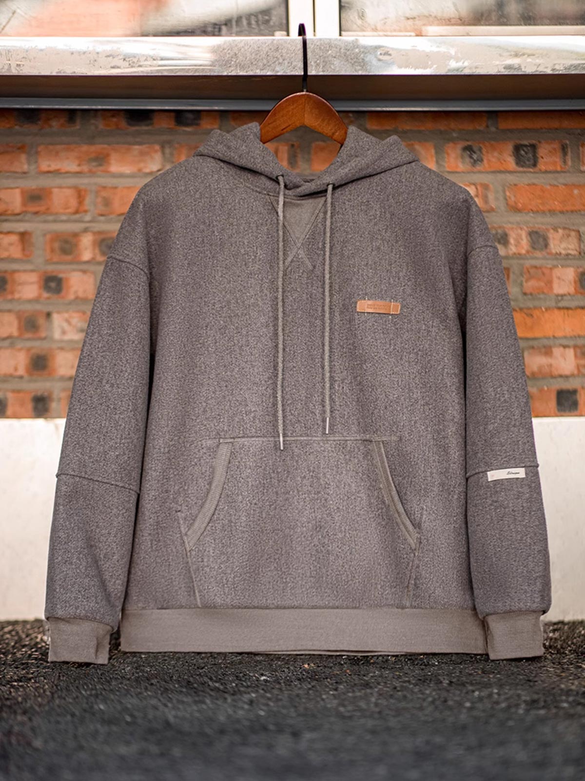 製品画像
ウール混フード付きパーカー、ダブルファブリックのミックス刺し毛加工を使用し、細かい起毛デザインが保温性と柔らかい肌触りを提供。レトロなディテールで、冬の寒さから守る優れた保温性を実現。
詳細画像
表面の細かい起毛デザインと、エンボスレザーラベル、袖口のリブ編みディテールが特徴。フードのドローコードと広めのポケットで、実用性とレトロなレイヤード感が強調されています。ダブルファブリックのミックス刺し毛加工が肌触りと保温性を向上。