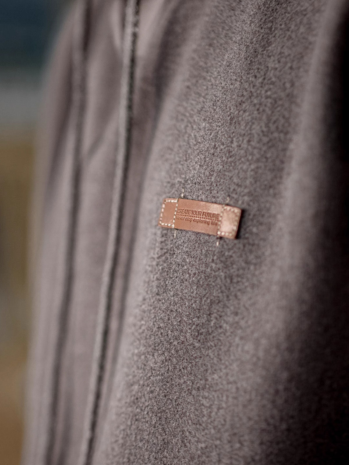 製品画像
ウール混フード付きパーカー、ダブルファブリックのミックス刺し毛加工を使用し、細かい起毛デザインが保温性と柔らかい肌触りを提供。レトロなディテールで、冬の寒さから守る優れた保温性を実現。
詳細画像
表面の細かい起毛デザインと、エンボスレザーラベル、袖口のリブ編みディテールが特徴。フードのドローコードと広めのポケットで、実用性とレトロなレイヤード感が強調されています。ダブルファブリックのミックス刺し毛加工が肌触りと保温性を向上。