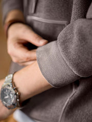 詳細画像
表面の細かい起毛デザインと、エンボスレザーラベル、袖口のリブ編みディテールが特徴。フードのドローコードと広めのポケットで、実用性とレトロなレイヤード感が強調されています。ダブルファブリックのミックス刺し毛加工が肌触りと保温性を向上。
モデル画像
冬のコーディネートに最適なウール混フード付きパーカーを着用したモデル。起毛デザインとレトロなディテールが際立ち、快適さと保温性を提供。