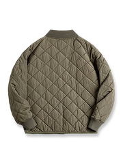 製品画像: レトロなキルティングベースボールジャケットデザイン中綿ジャケット正面展示画像。クラシックなベースボールジャケットのシルエットに、精緻なキルティング技術とオレンジ色の手刺繍ディテールが特徴。光沢ナイロン素材とポリエステル繊維で暖かさとスタイルを提供します。
詳細画像: キルティングベースボールジャケットのステッチポケットとオレンジ色の手刺繍風ディテールのクローズアップ。銅製スナップボタンのディテールと、均等に分布した中綿が暖かさを保証。