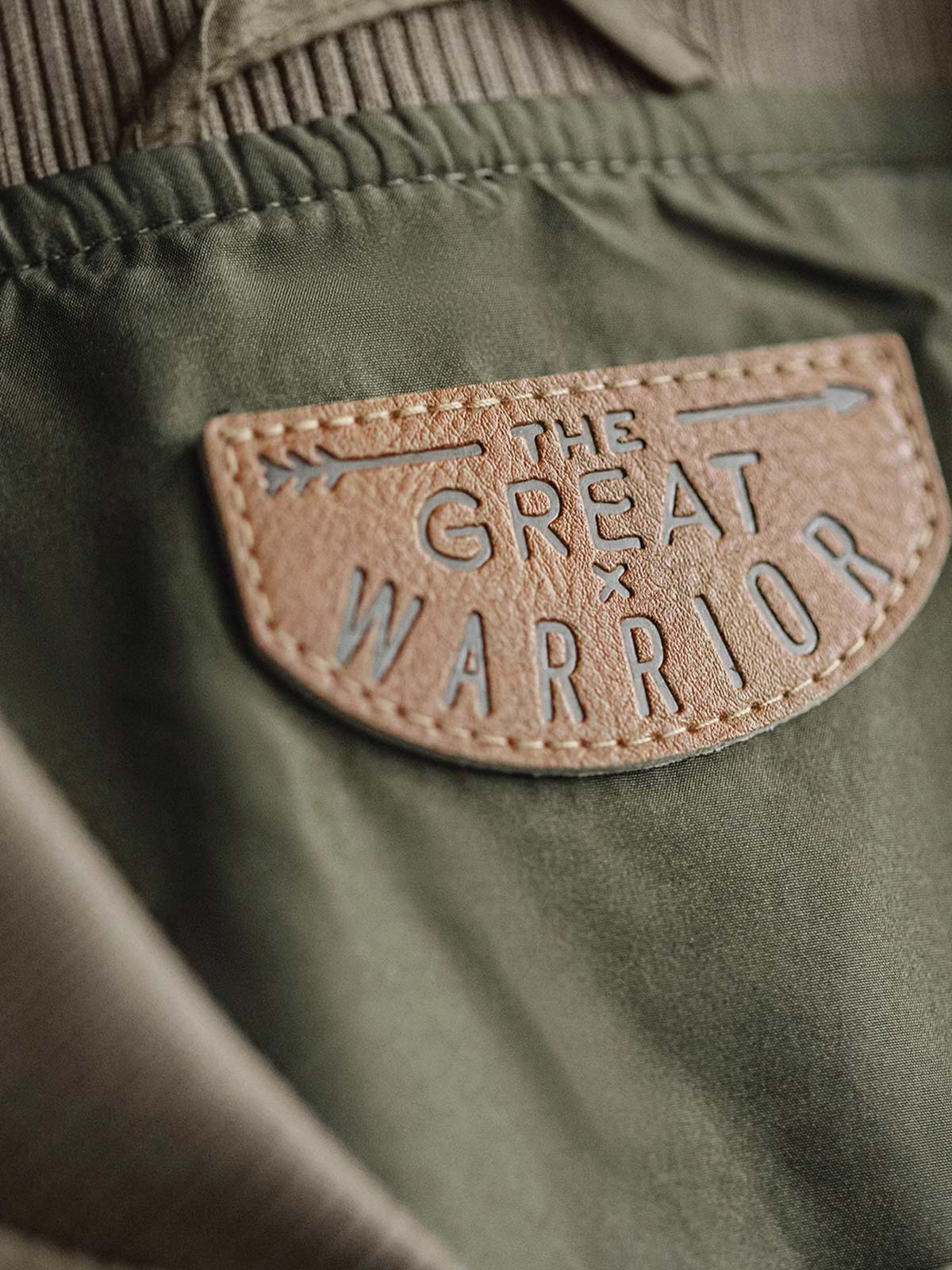 製品画像: レトロなキルティングベースボールジャケットデザイン中綿ジャケット正面展示画像。クラシックなベースボールジャケットのシルエットに、精緻なキルティング技術とオレンジ色の手刺繍ディテールが特徴。光沢ナイロン素材とポリエステル繊維で暖かさとスタイルを提供します。
詳細画像: キルティングベースボールジャケットのステッチポケットとオレンジ色の手刺繍風ディテールのクローズアップ。銅製スナップボタンのディテールと、均等に分布した中綿が暖かさを保証。