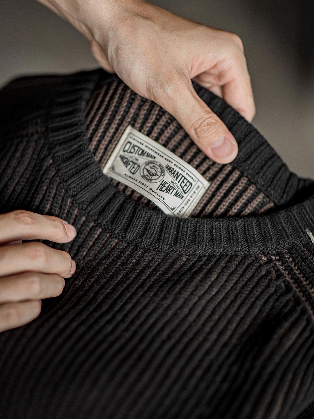 製品画像:クラシックなアメリカンカジュアルスタイルのストライプ編みセーター、ラグランスリーブデザインと柳編み風デザインが特徴。ブラウンとブラックの配色がシンプルでありながら質感を引き立て、リラックス感のある着心地。
詳細画像:ストライプ編みのデザインアップ、ラグランスリーブと柳編み風のディテール、ブラウンとブラックの配色で個性を引き立て。リブ編みの裾がフィット感を提供。