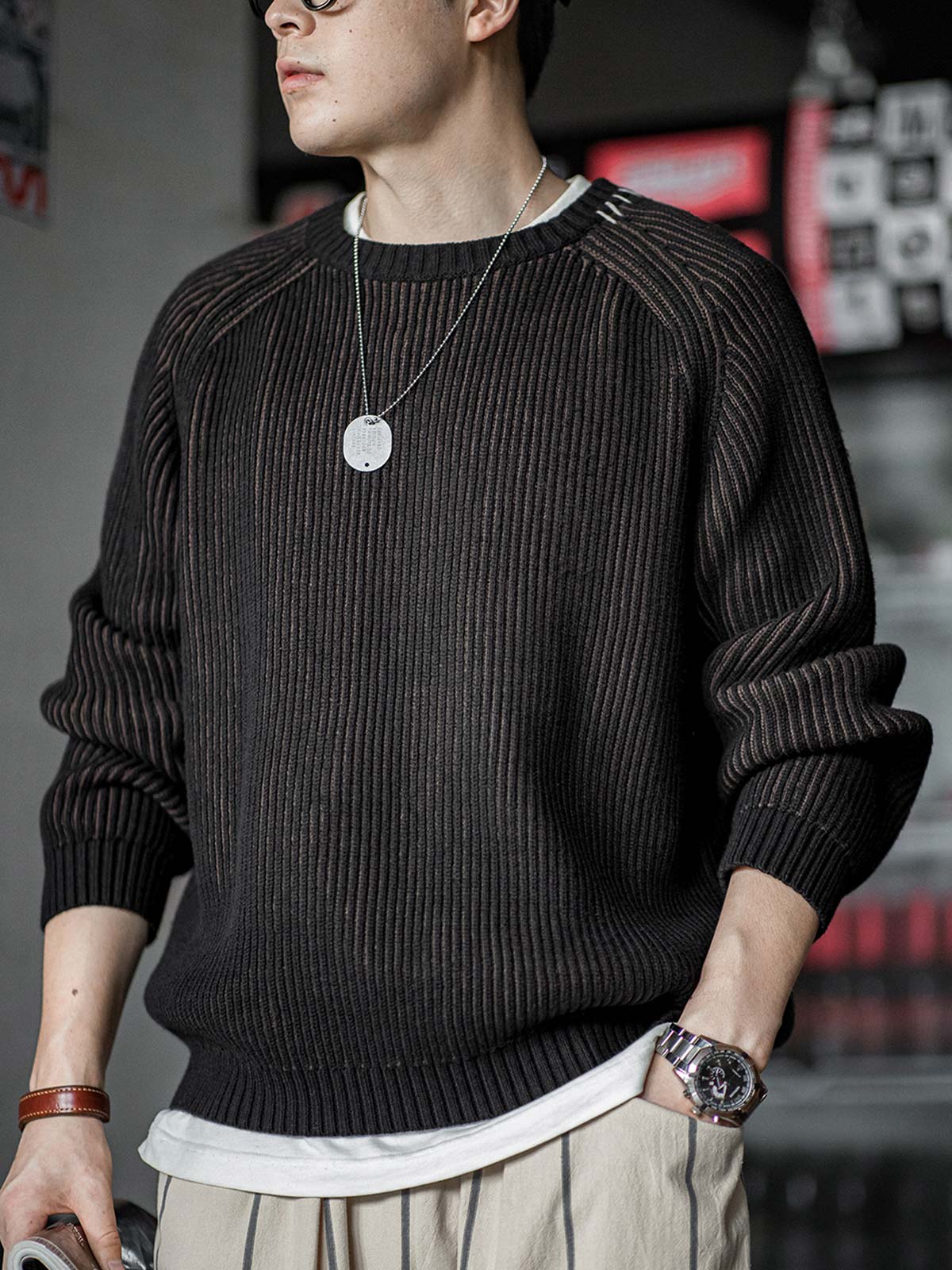 詳細画像:ストライプ編みのデザインアップ、ラグランスリーブと柳編み風のディテール、ブラウンとブラックの配色で個性を引き立て。リブ編みの裾がフィット感を提供。
モデル画像:モデルがストライプ編みセーターを着用、アメリカンカジュアルスタイルでリラックス感あるシルエット、日常コーディネートにぴったりなデザイン。