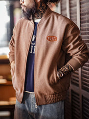 詳細画像:
"アメカジグラフィティ要素を取り入れた立体刺繍と、背面の牛革紙ラベルのディテールクローズアップ。袖口と裾のリブ編みがヴィンテージ感と着心地の良さを強調"
モデル画像:
"アメカジヴィンテージスタイルのウール混紡ベースボールジャケットを着用した、日常のトレンドコーディネート。リブ編みの袖口と裾がアクセントになったカジュアルスタイル"