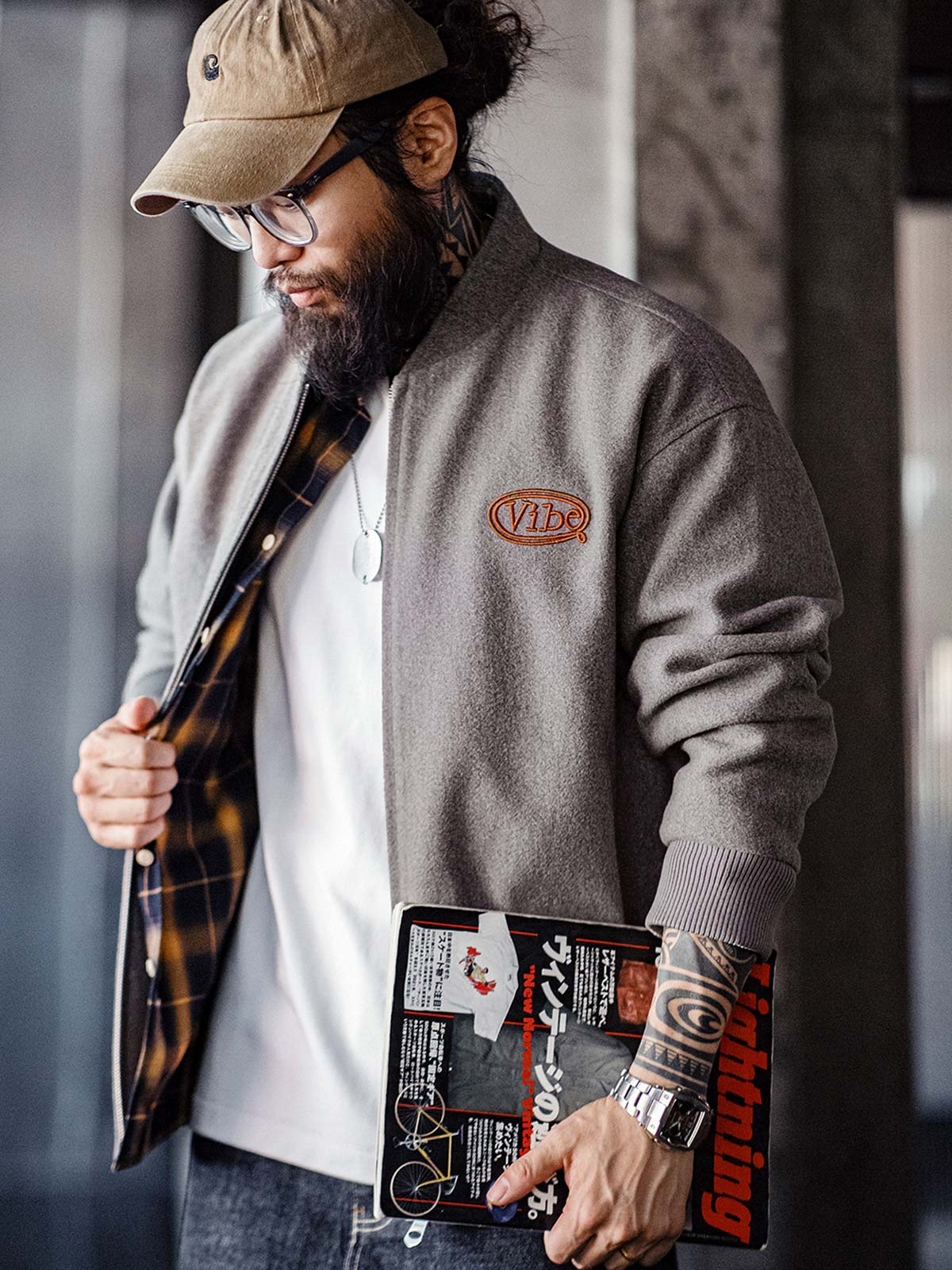 詳細画像:
"アメカジグラフィティ要素を取り入れた立体刺繍と、背面の牛革紙ラベルのディテールクローズアップ。袖口と裾のリブ編みがヴィンテージ感と着心地の良さを強調"
モデル画像:
"アメカジヴィンテージスタイルのウール混紡ベースボールジャケットを着用した、日常のトレンドコーディネート。リブ編みの袖口と裾がアクセントになったカジュアルスタイル"