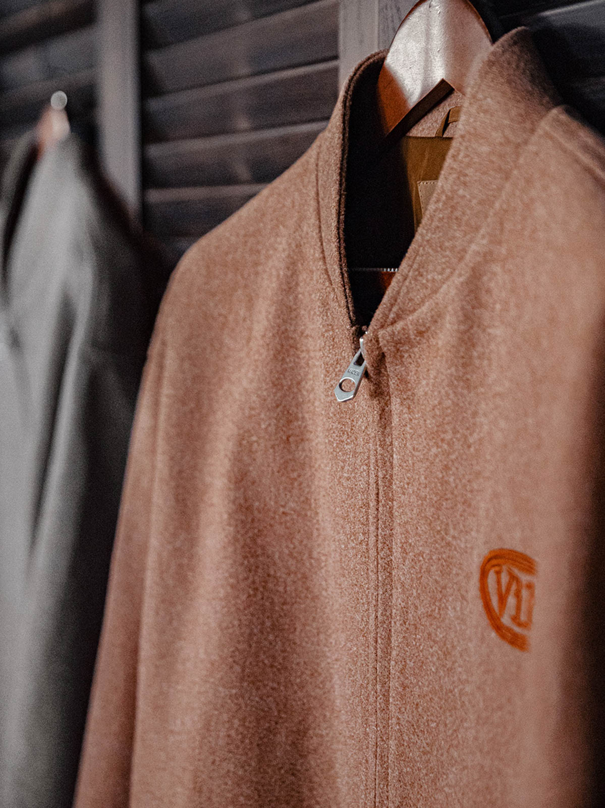 詳細画像:
"アメカジグラフィティ要素を取り入れた立体刺繍と、背面の牛革紙ラベルのディテールクローズアップ。袖口と裾のリブ編みがヴィンテージ感と着心地の良さを強調"
モデル画像:
"アメカジヴィンテージスタイルのウール混紡ベースボールジャケットを着用した、日常のトレンドコーディネート。リブ編みの袖口と裾がアクセントになったカジュアルスタイル"