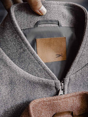 詳細画像:
"アメカジグラフィティ要素を取り入れた立体刺繍と、背面の牛革紙ラベルのディテールクローズアップ。袖口と裾のリブ編みがヴィンテージ感と着心地の良さを強調"
モデル画像:
"アメカジヴィンテージスタイルのウール混紡ベースボールジャケットを着用した、日常のトレンドコーディネート。リブ編みの袖口と裾がアクセントになったカジュアルスタイル"