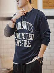 詳細画像
「フロック加工のロゴプリントと起毛素材の滑らかな肌触りをクローズアップ。背面の刺繍アーチロゴや裾のラバープリントタグもディテールとして特徴的。」
モデル画像
「モデルがフロック加工ロゴプリント長袖Tシャツを着用し、ドロップショルダーとクルーネックが特徴のアメリカンストリートスタイルを披露。」