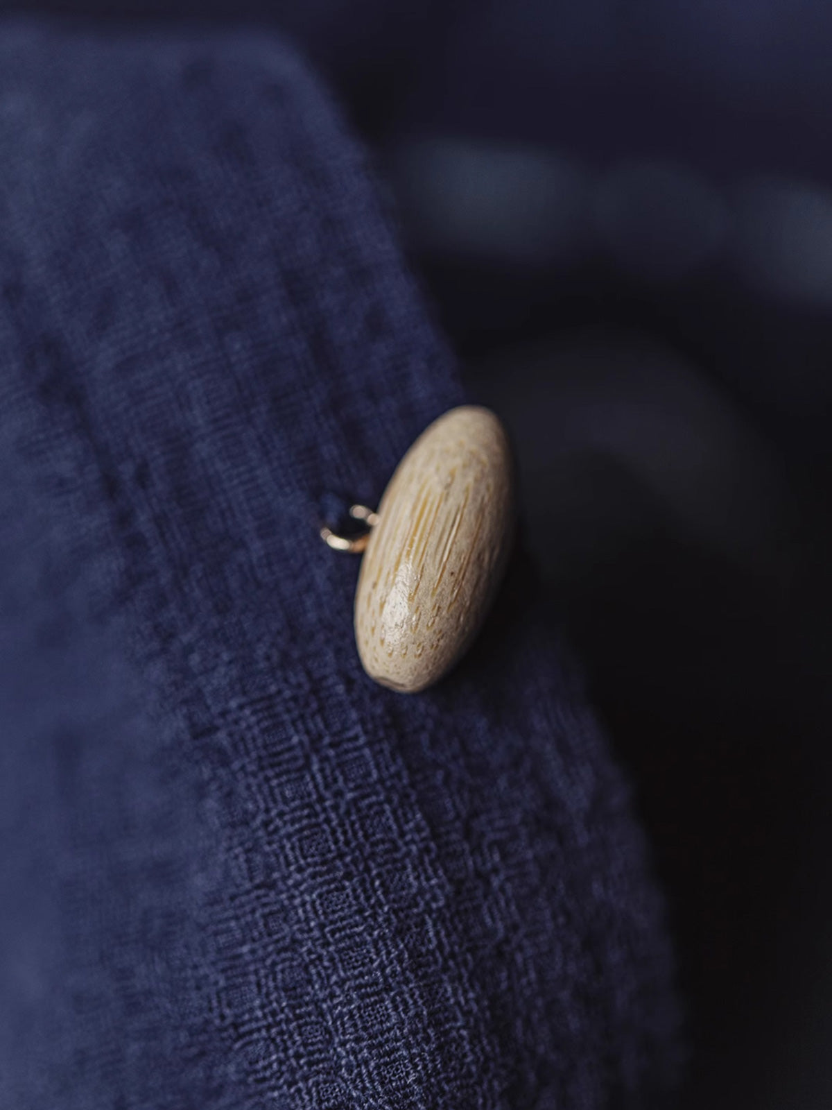 フーディの襟元にある竹製オリーブ形ボタンとレザーのシルクスクリーンプリントヴィンテージロゴの詳細画像
