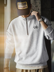 詳細画像
「ハーフジップ スタンドカラー スウェットのディテールクローズアップ。コントラストパイピング仕上げと刺繍されたオールモチーフがアクセントになった霜降り模様の中空構造素材の特徴を強調」
モデル画像
「ハーフジップ スタンドカラー スウェットを着用したコーディネート例。霜降り模様の中空構造素材とルーズフィットシルエットで、日常使いやアウトドアスタイルに最適な秋冬のカジュアルファッション」