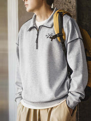 詳細画像
「ハーフジップ スタンドカラー スウェットのディテールクローズアップ。コントラストパイピング仕上げと刺繍されたオールモチーフがアクセントになった霜降り模様の中空構造素材の特徴を強調」
モデル画像
「ハーフジップ スタンドカラー スウェットを着用したコーディネート例。霜降り模様の中空構造素材とルーズフィットシルエットで、日常使いやアウトドアスタイルに最適な秋冬のカジュアルファッション」