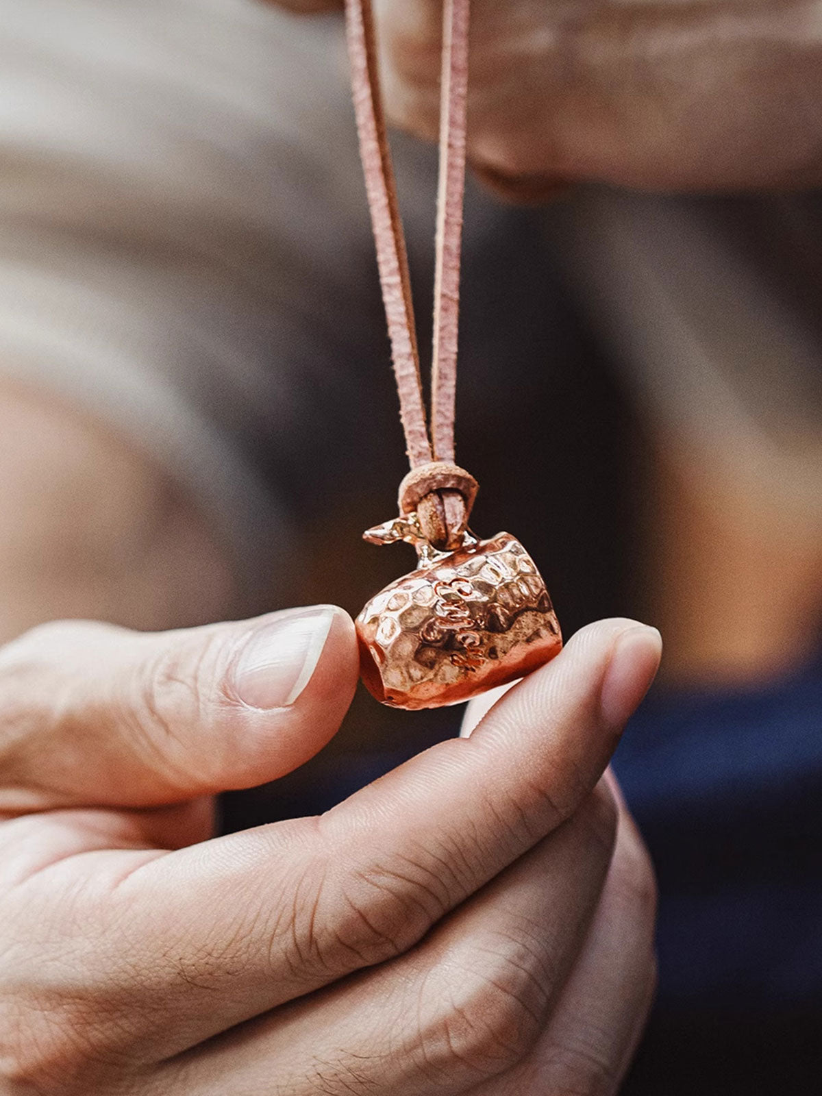 製品画像
ハンドメイドで仕上げられたハンマーテクスチャーが美しい銅カップペンダント。全体的にヴィンテージ感を強調したデザインで、時間の経過とともに味わい深いアンティークな色合いが楽しめます。レザーコード付きでカジュアルからフォーマルまで幅広く対応可能なアクセサリー
詳細画像
職人の手作業によるハンマーテクスチャーのディテールと、丁寧に彫刻された英文字刻印が印象的な銅カップペンダント。細部にまでこだわりが詰まった表面デザインが、独自のクラフトマンシップを感じさせます。自然な酸化による変化が楽しめる素材感も魅力