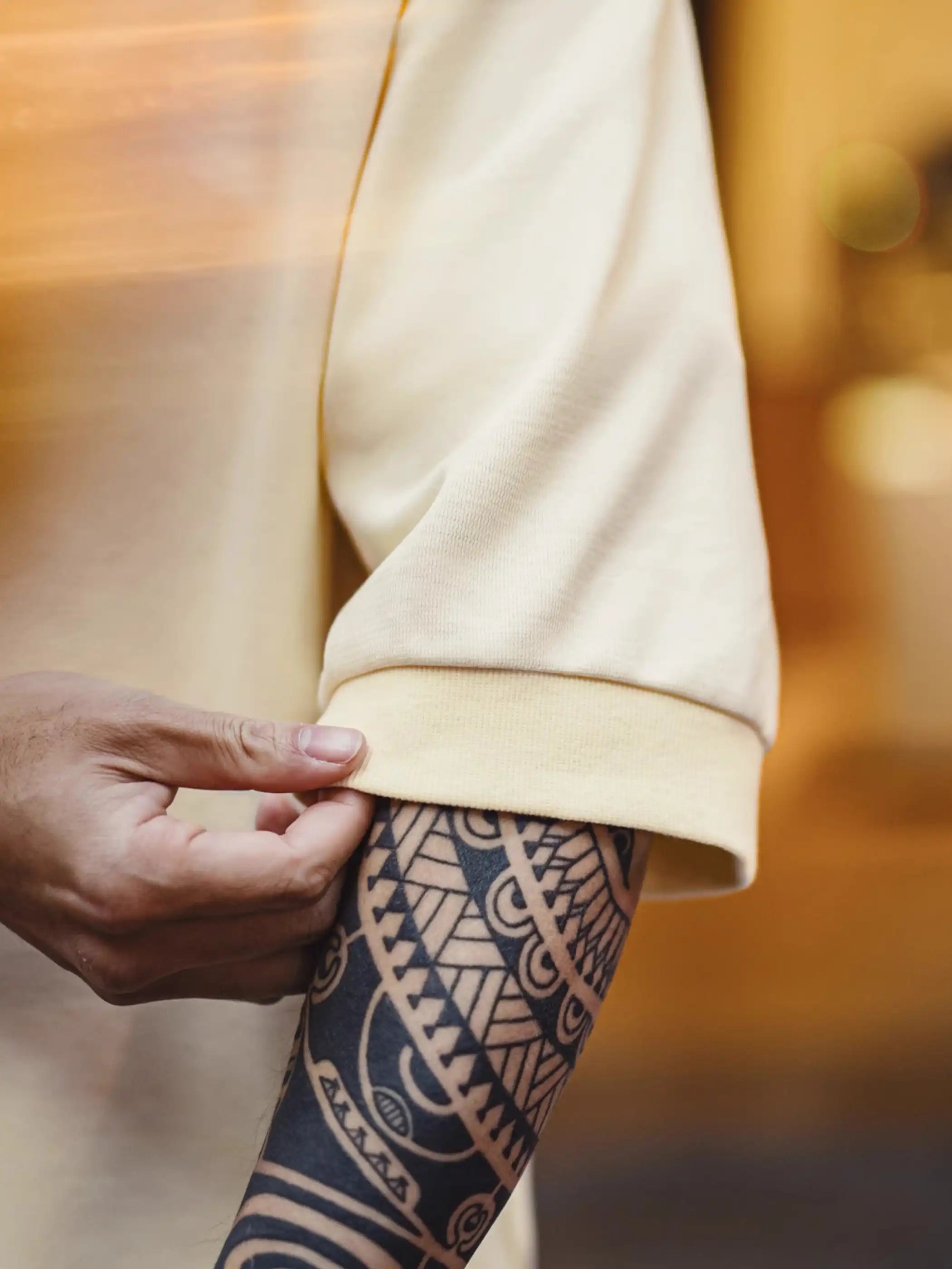 ゆったりとしたドロップショルダーTシャツ、背面上部に同色の波形刺繍が施されている