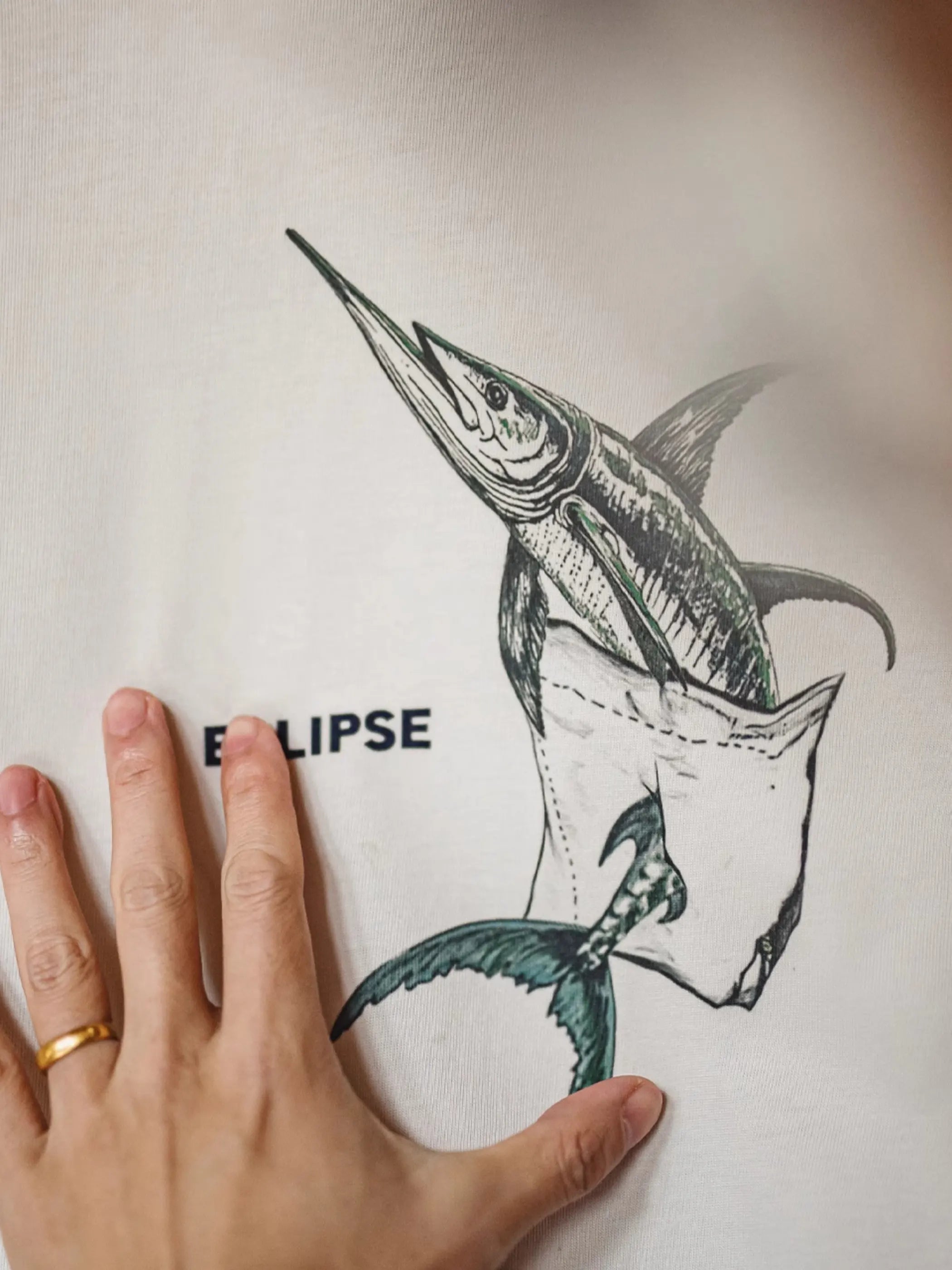 ポケット位置にマーリン錯視プリントを配したホワイトTシャツ