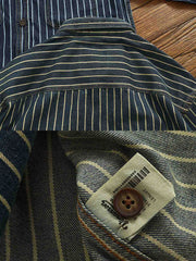 製品画像: ヘビーストライプデニムワークシャツの正面展示
詳細画像: 肘のパッチとストライプのディテールクローズアップ
モデル画像