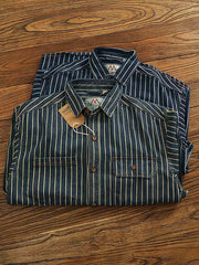 製品画像: ヘビーストライプデニムワークシャツの正面展示
詳細画像: 肘のパッチとストライプのディテールクローズアップ
モデル画像