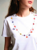 詳細画像: フラワーバッドネックレスTシャツの詳細図、精緻な花蕾刺繍とリブ付きクルーネックを展示