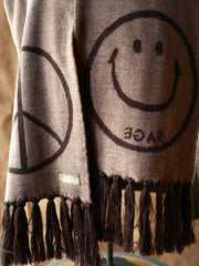 製品画像:
"柔らかい光沢感のあるウールスマイルマフラーの全体図。スマイルロゴとピースマークがデザインされた両面デザインが特徴的で、秋冬にぴったりな上品で快適なアクセサリー"
詳細画像:
"ジャカードフリンジと両面デザインの細部クローズアップ。シルクのような滑らかさを持つ光沢感のあるウール素材を使用し、立体感を引き立てる装飾"
