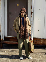 詳細画像:
"ジャカードフリンジと両面デザインの細部クローズアップ。シルクのような滑らかさを持つ光沢感のあるウール素材を使用し、立体感を引き立てる装飾"
モデル画像:
"柔らかい光沢感のあるウールスマイルマフラーを身に着けたエレガントで暖かい秋冬コーディネート。スマイルロゴとピースマークがアクセントになったスタイリング"